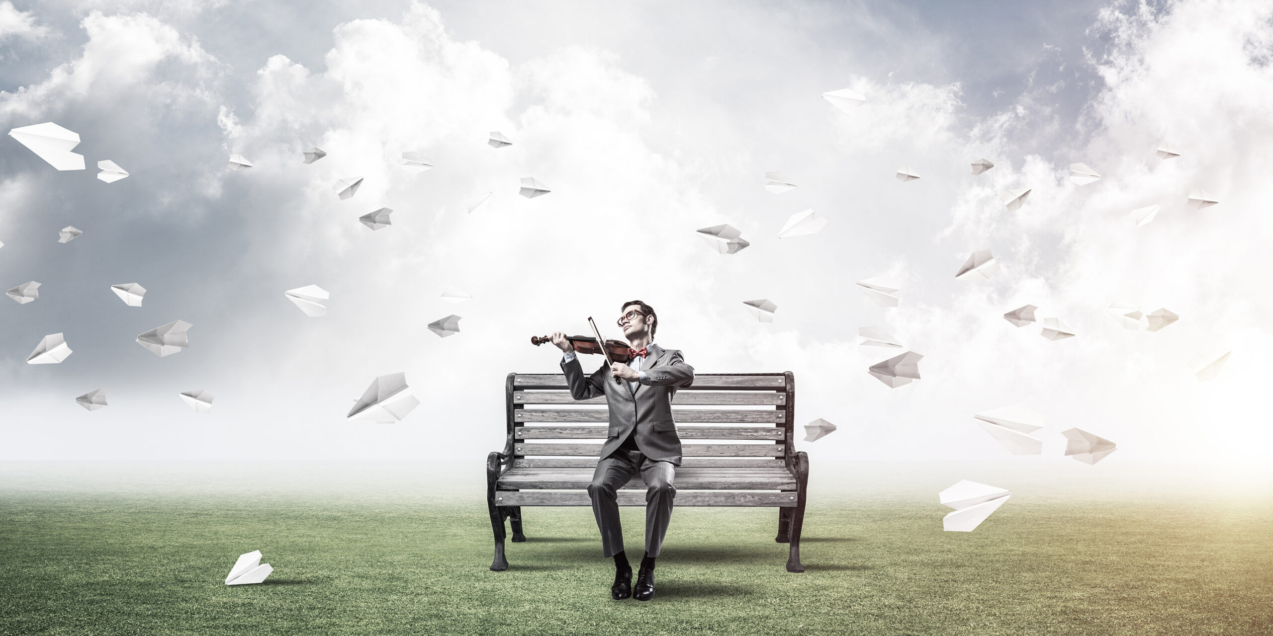 Young Man Wearing Suit And Glasses Sitting On Bench And Playing